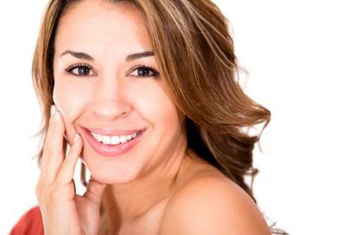 Woman touching face with hand