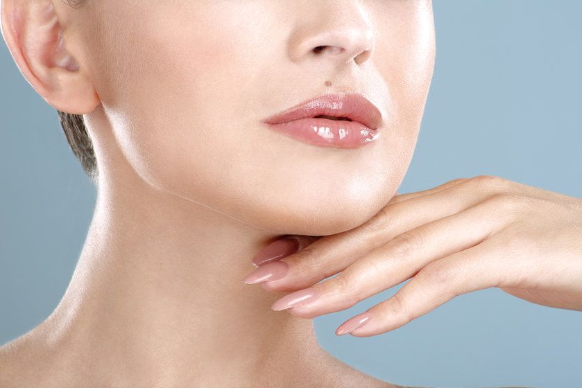 Woman's lower face with hand under jaw
