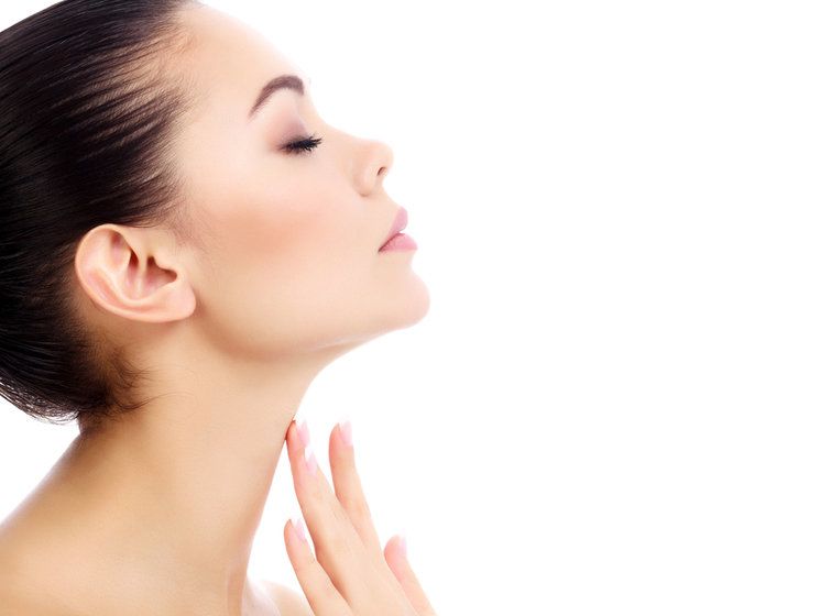 Woman holding fingers to shapely neck