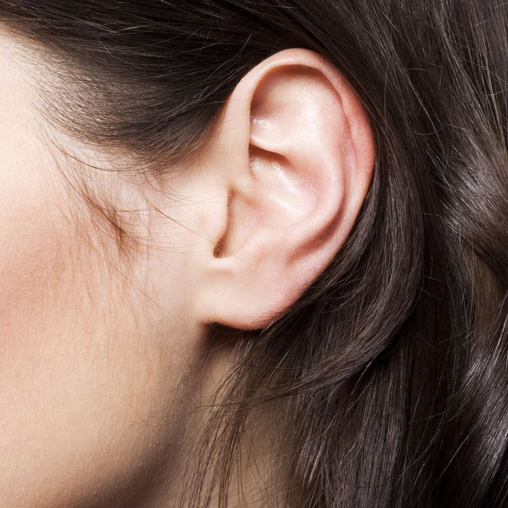 Close up of brunette's ear and hair tucked behind ear