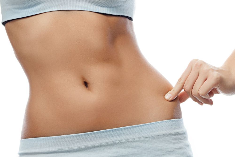 Woman's toned midsection and fingers pinching side