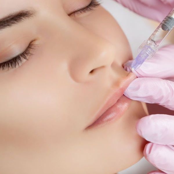 Woman receiving lip injectables