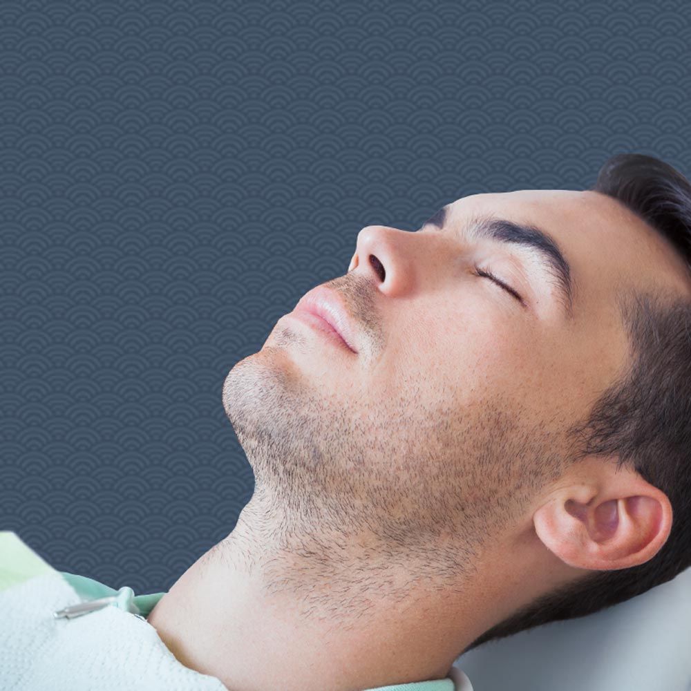 Man sitting in dentist's chair with eyes closed