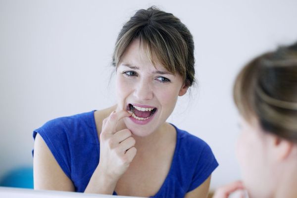 WOMAN INSPECTING TOOTH