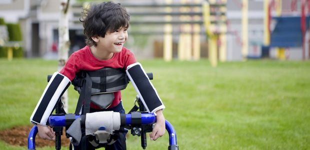 Young boy with cerebral palsy playing outdoors