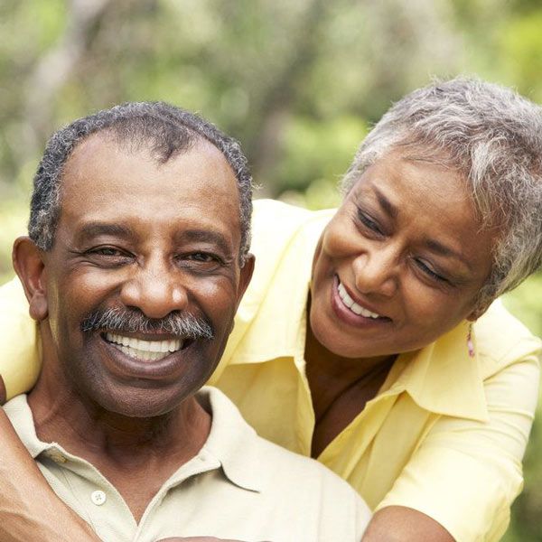 Elderly couple smiling after implants treatment