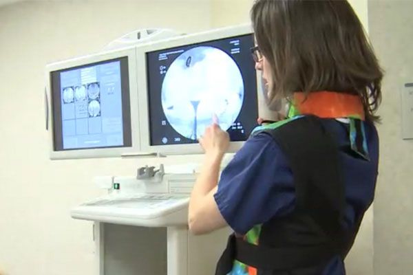 Image of woman explaining the readout on a monitor at the infertility clinic.