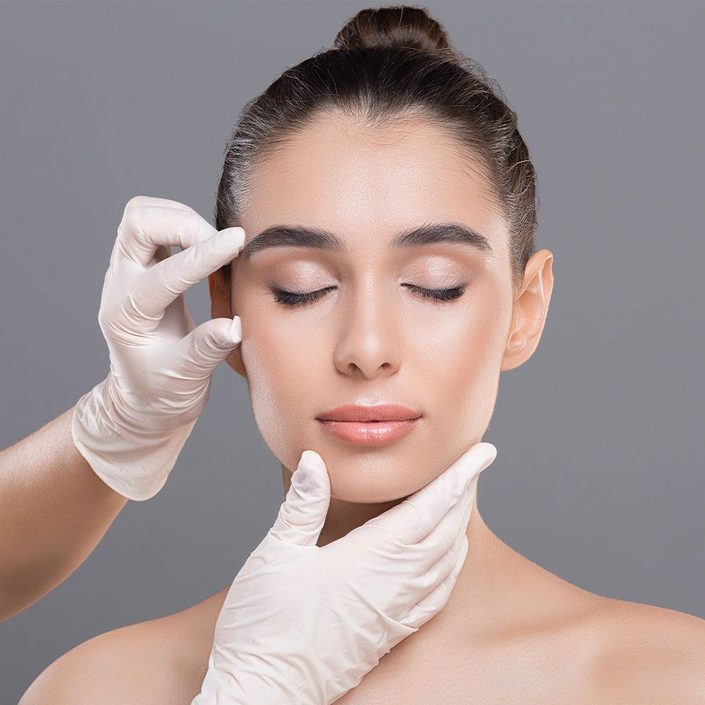 Gloved hand touching beautiful woman's brow