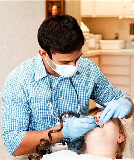 Cosmetic Dentist: Photo of Dr. Donald Ross standing next to a dental chair, from the back.