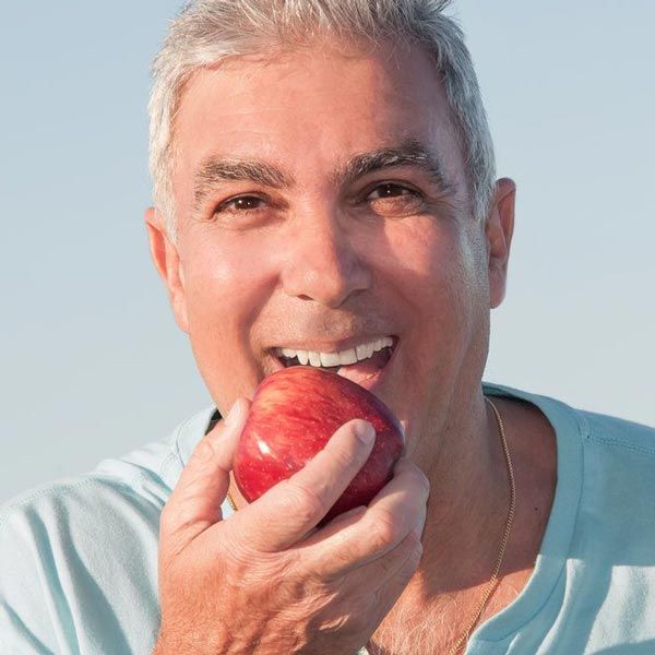 Older man biting into apple