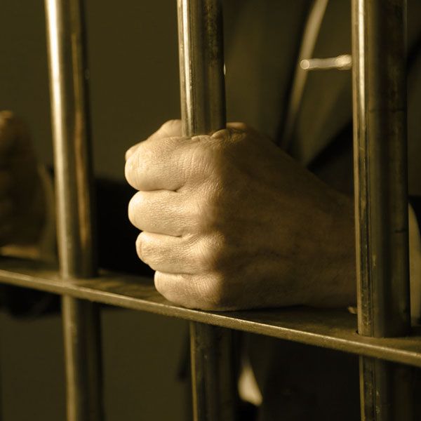 Hand gripping jail cell bars