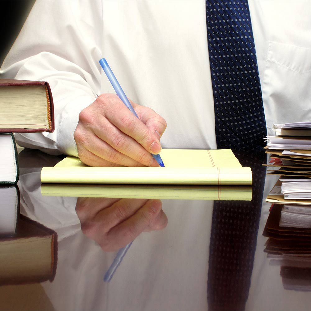 Office worker writing on legal pad