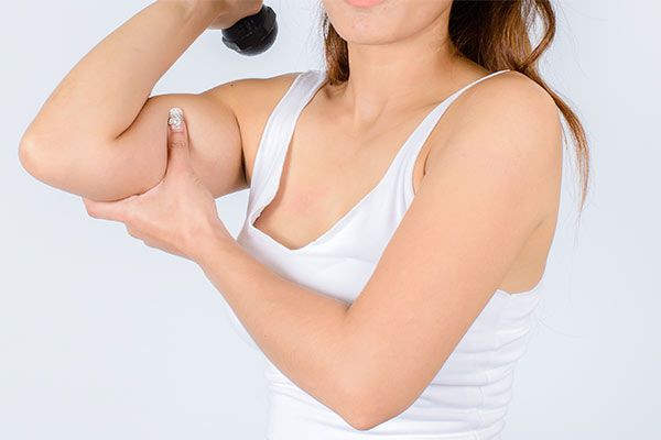 Woman's bicep as she lifts weight