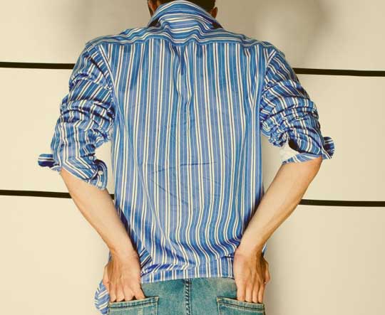 A man facing a wall as part of a police lineup