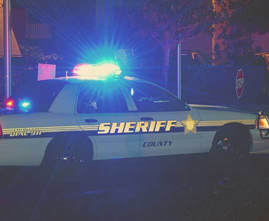 A woman using her phone at the scene of a car accident