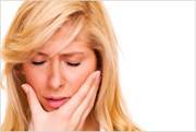 Woman holding her lower face in pain