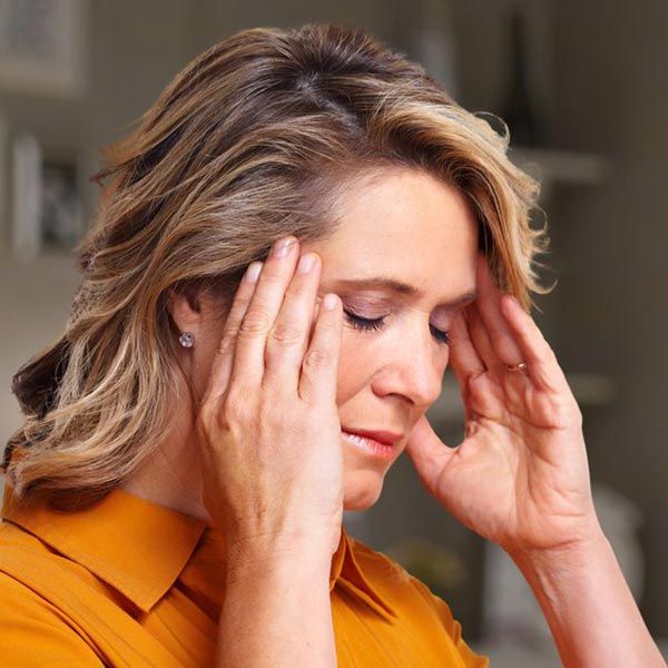 Woman holding head in pain