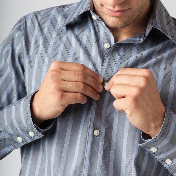Man buttoning shirt