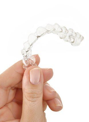 Hand holding a clear aligner tray