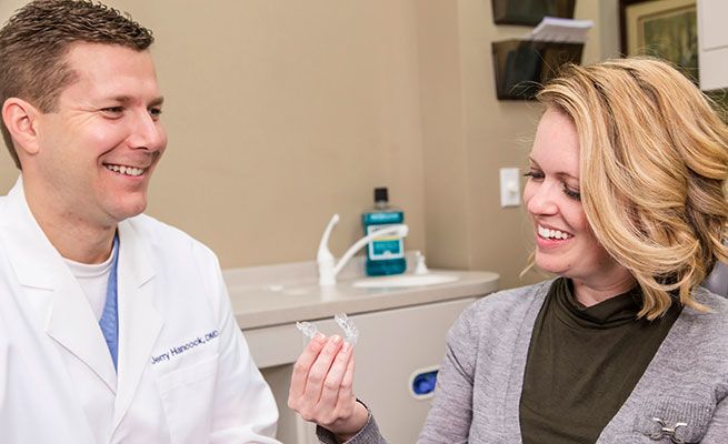 Dr. Hancock showing a patient an Invisalign® tray