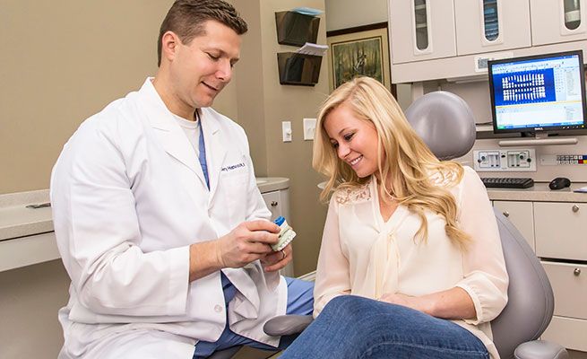 Dr. Hancock showing patient a wax-up model