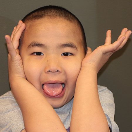 Asian boy making silly face for photo