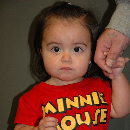 Cute little girl with minnie mouse shirt holding adult hand