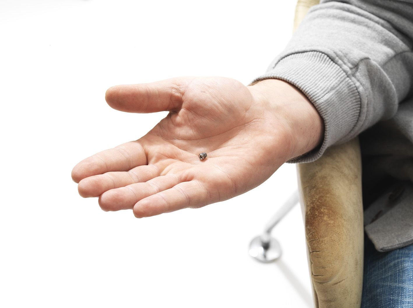 Man holding BAHA implant in his palm