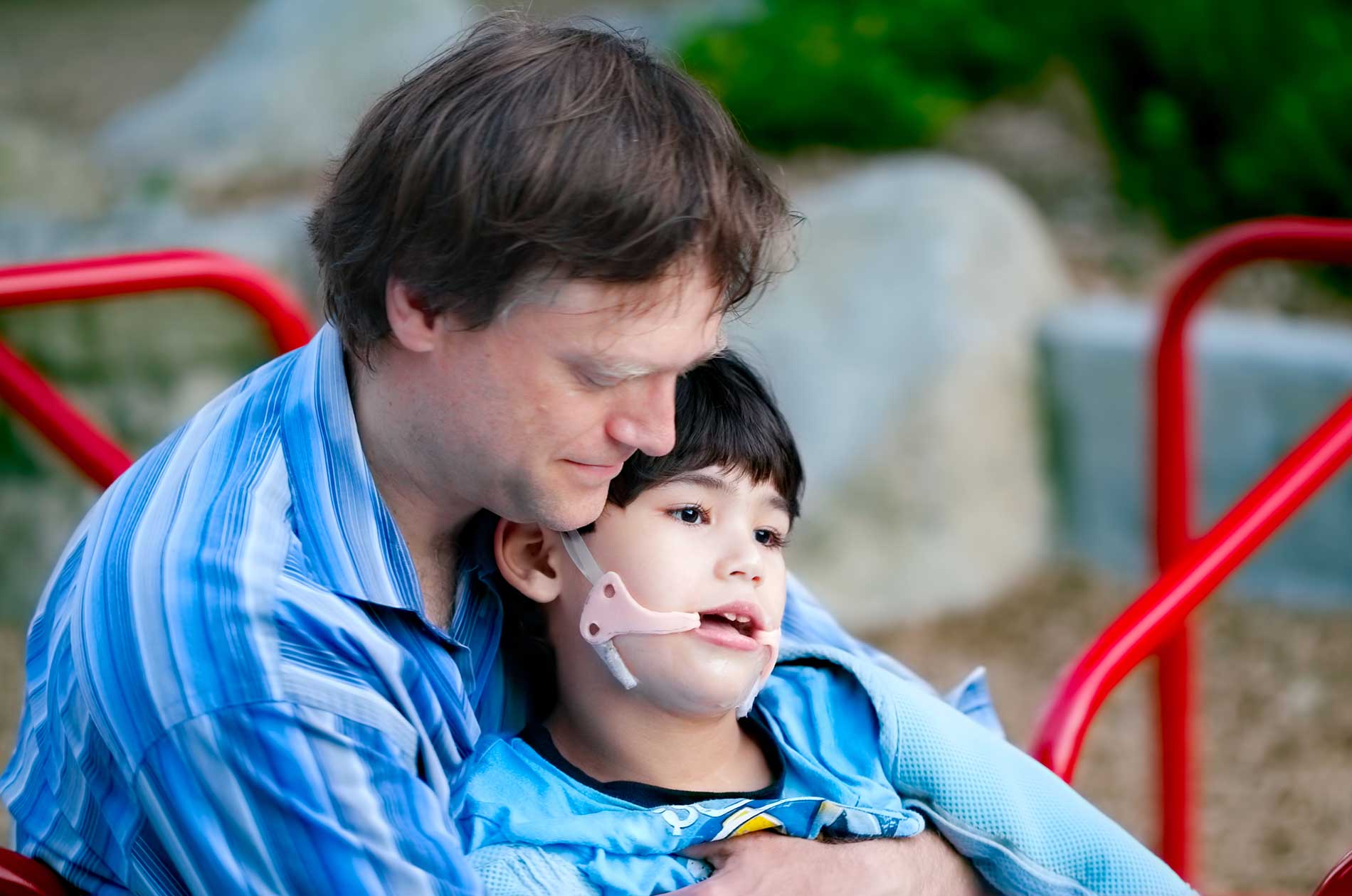 A man holding a child who suffers from cerebral palsy