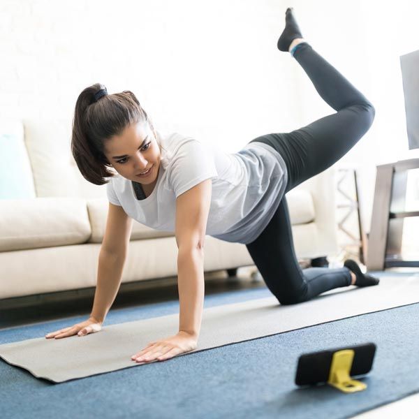 Woman following an at-home workout video on her phone