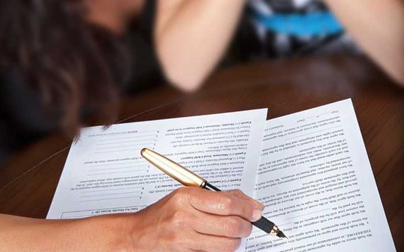 Woman holding pen and completing paperwork