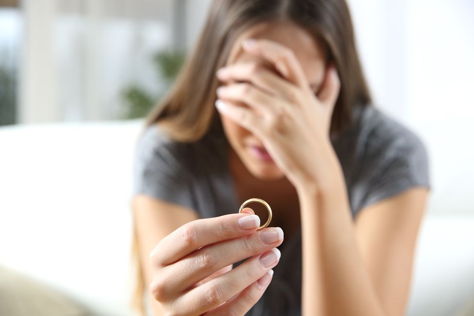 Sad woman holding a wedding ring