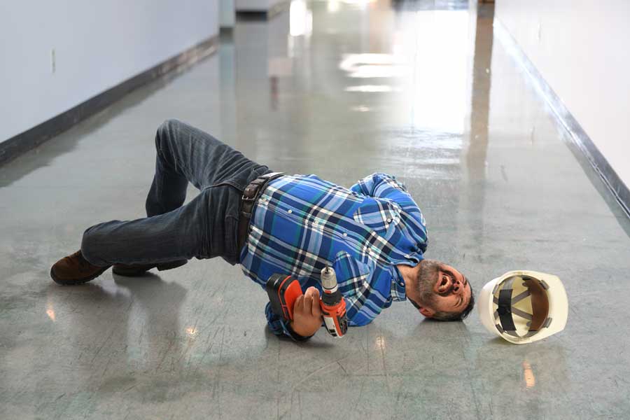 A man writhes on the floor in pain