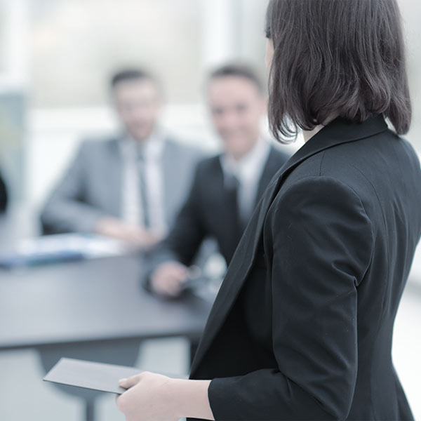 Woman at work with blurred men in the background laughing