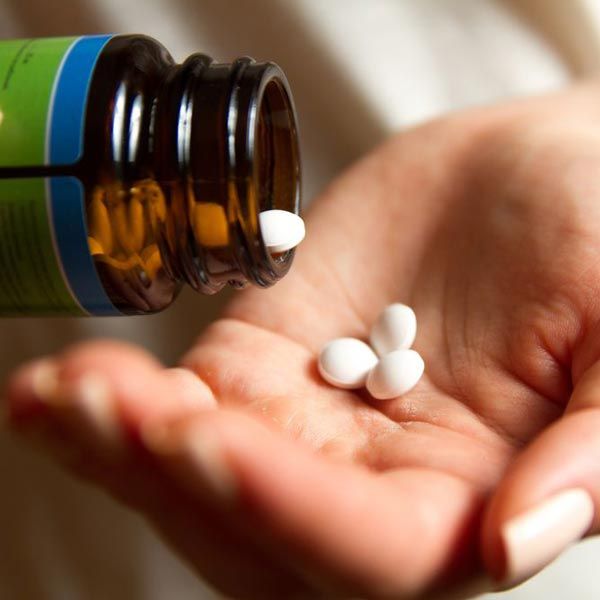 Patient pouring several pills into hand