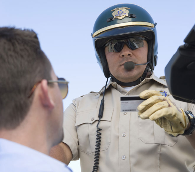 Cop holding ID and talking with driver