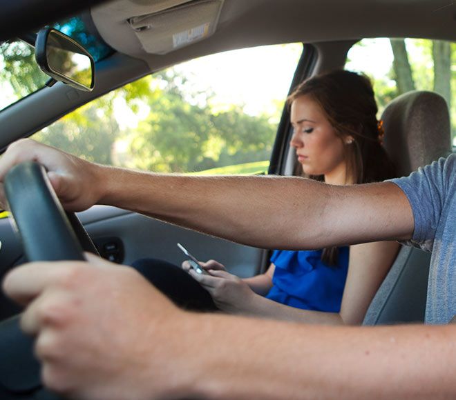 Adult driving with teenager in passenger seat