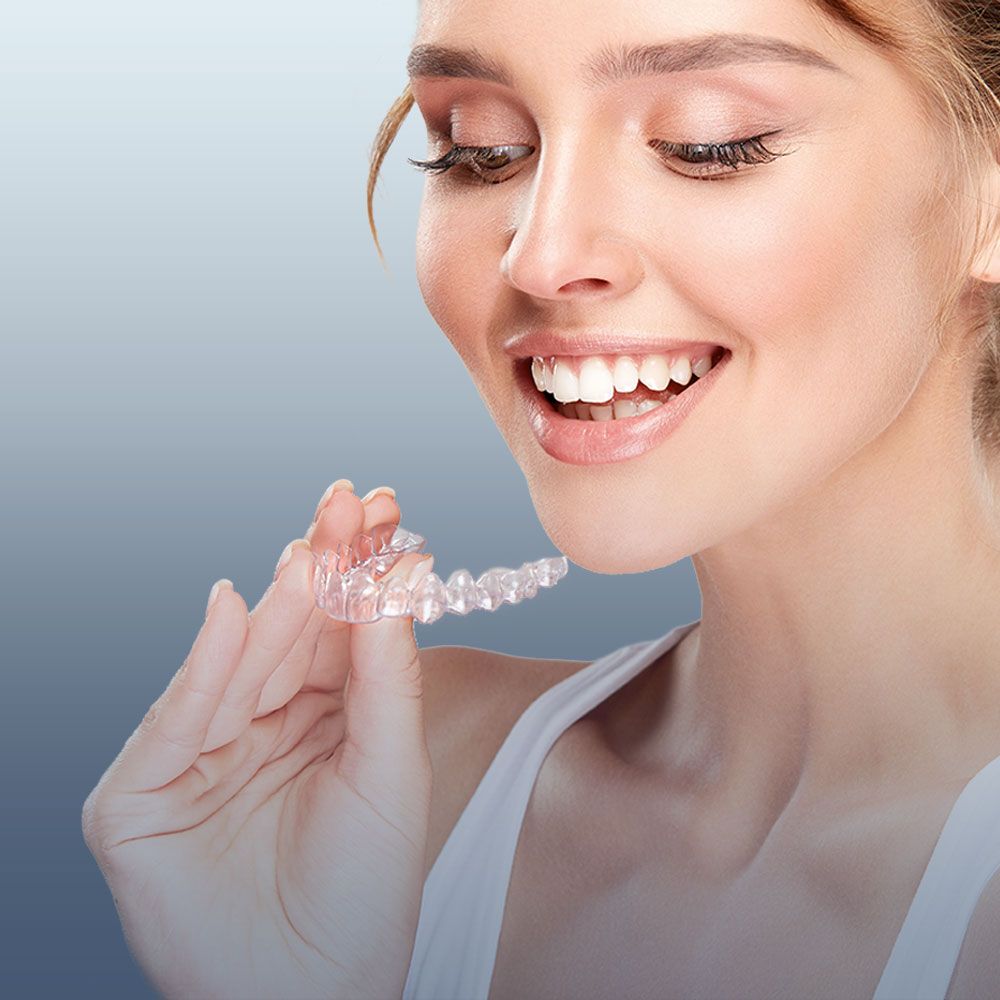 woman holding clear aligner