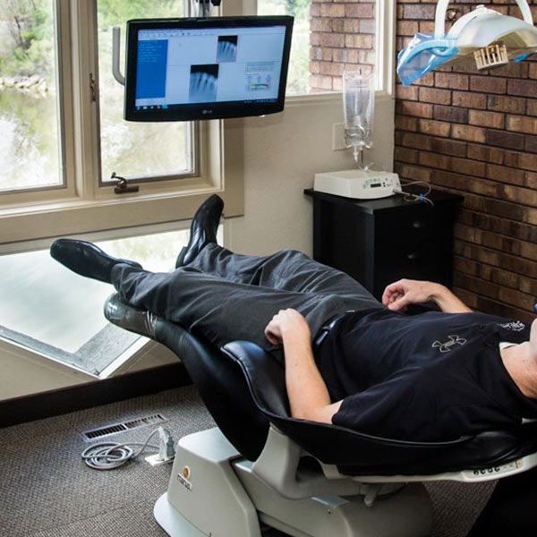 a patient laying back in the dentist's chair