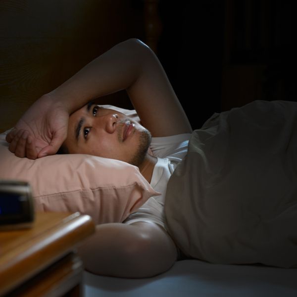 Man in bed with arm over head