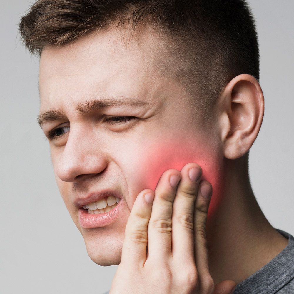 Man holding jaw in pain