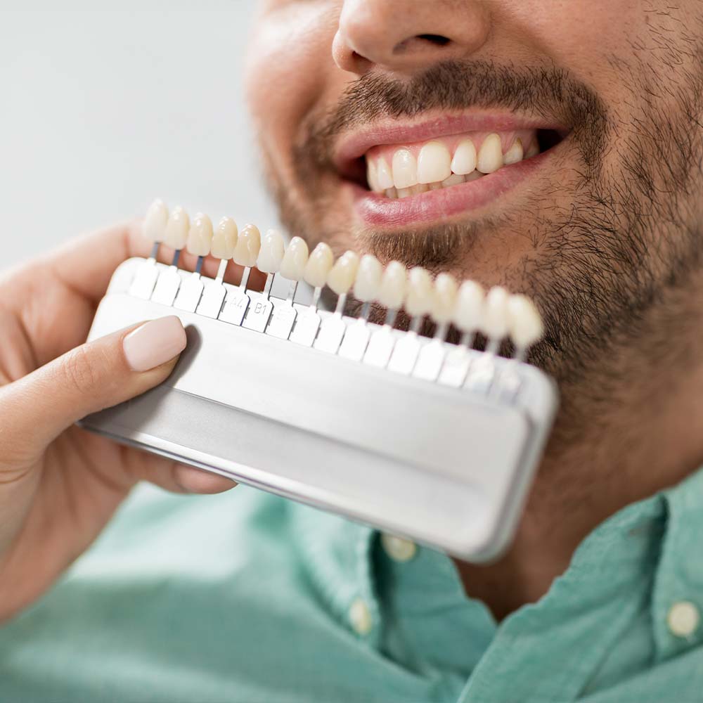 Fake teeth held up to a patient's mouth