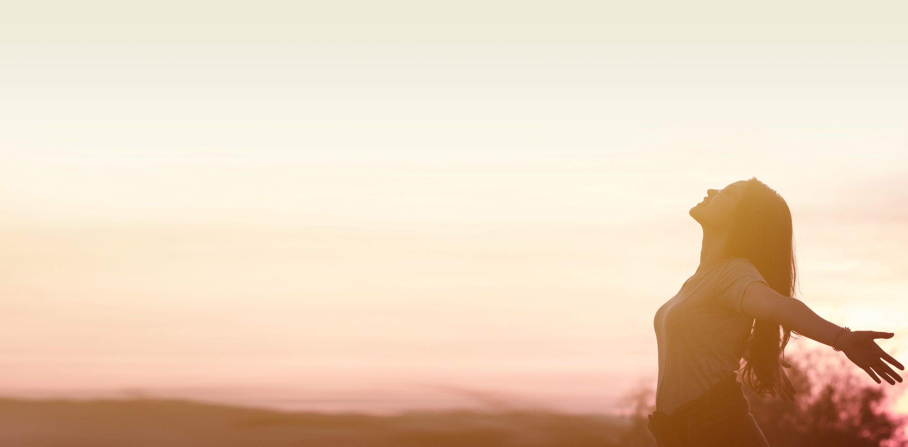 Woman on beach with outstretched arms